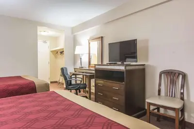 a hotel room with a bed and a television and a desk at Econo Lodge in Orillia