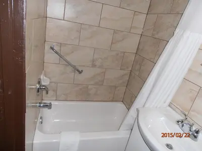 a bathroom with a tub and a toilet and a sink at Maples Motel in Orillia