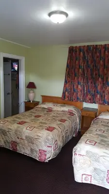 a hotel room with two beds and a window at Maples Motel in Orillia