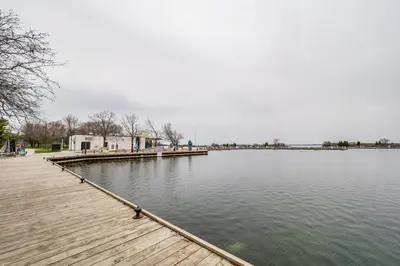 a dock on a body of water with a building at Maples Motel in Orillia