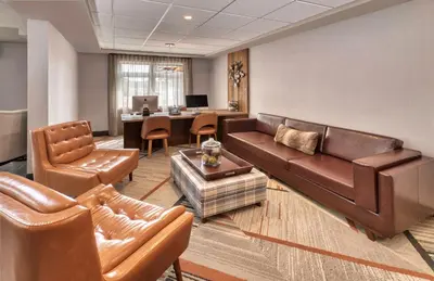 a living room with a couch and chairs and a desk at Four Points by Sheraton Barrie in Barrie