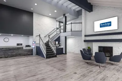 a lobby with two chairs and a staircase at Travelodge by Wyndham Barrie in Barrie