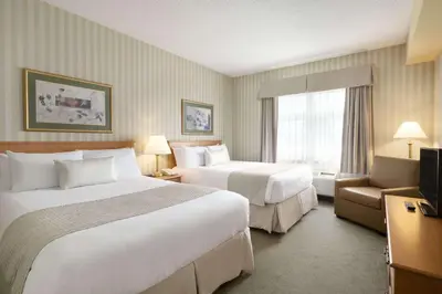 a hotel room with two beds and a television at Days Inn by Wyndham Orillia in Orillia