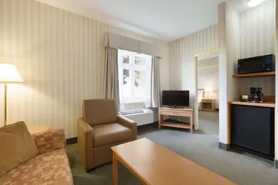 a living room with a couch and a chair and a television at Days Inn by Wyndham Orillia in Orillia