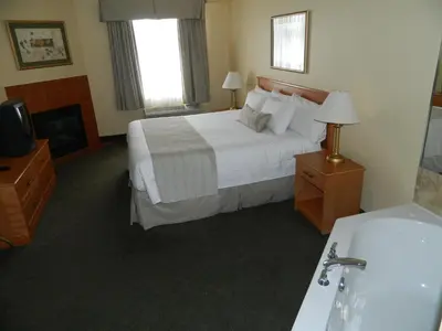 a hotel room with a bed and a bath tub at Days Inn by Wyndham Orillia in Orillia
