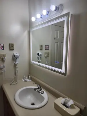 a bathroom with a sink and a large mirror at Howard Johnson by Wyndham Lindsay in Lindsay