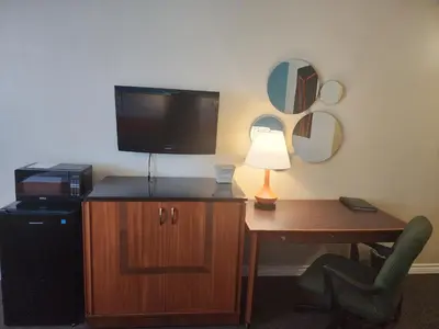a room with a desk with a television and a desk sidx sidx sidx at Howard Johnson by Wyndham Lindsay in Lindsay