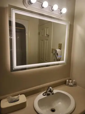 a bathroom with a sink and a large mirror at Howard Johnson by Wyndham Lindsay in Lindsay