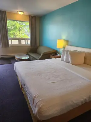 a hotel room with a large bed and a couch at Howard Johnson by Wyndham Lindsay in Lindsay