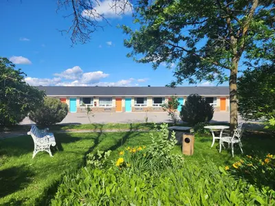 a garden with two chairs and a table and a building at Howard Johnson by Wyndham Lindsay in Lindsay