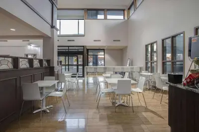 a dining room with white tables and white chairs at Days Inn by Wyndham Barrie in Barrie