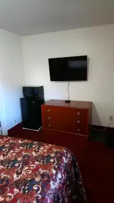 a hotel room with a bed and a flat screen tv at Relax Inn-Collingwood in Collingwood