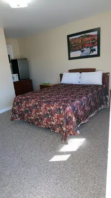 a bedroom with a large bed with a blanket on it at Relax Inn-Collingwood in Collingwood
