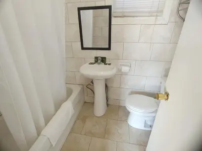 a bathroom with a sink and a toilet and a bath tub at Relax Inn-Collingwood in Collingwood