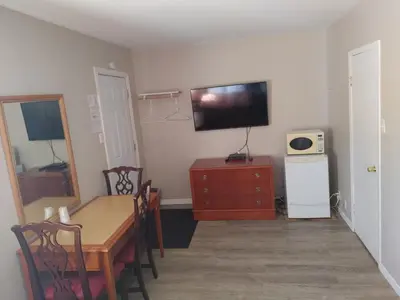 a room with a table and a television on the wall at Relax Inn-Collingwood in Collingwood