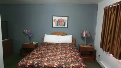 a bedroom with a bed with a comforter and pillows at Relax Inn-Collingwood in Collingwood