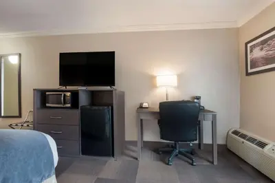 a hotel room with a desk and a bed and a television at Best Western St Catharines Hotel & Conference Centre in St. Catharines