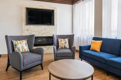 a living room with three chairs and a tv at Comfort Inn & Suites in Barrie