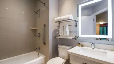 a bathroom with a sink and a toilet and a mirror at Best Western Plus Barrie in Barrie