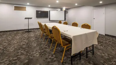 a conference room with a table and chairs and a screen at Best Western Plus Barrie in Barrie