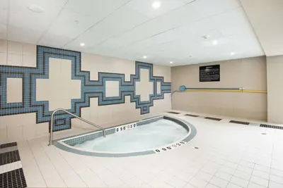 a swimming pool in a room with a mosaic wall at Hampton Inn & Suites by Hilton Barrie in Barrie