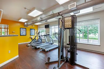a gym with several tread machines in a room with yellow walls at Best Western Milton in Milton