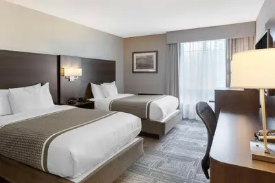 a hotel room with two beds and a desk at Best Western Milton in Milton