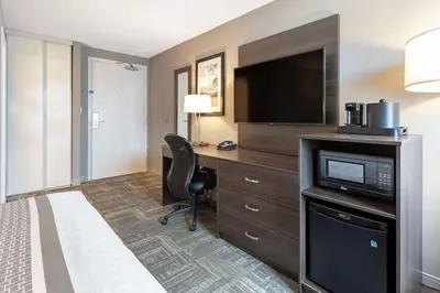 a hotel room with a bed and a desk with a television at Best Western Milton in Milton