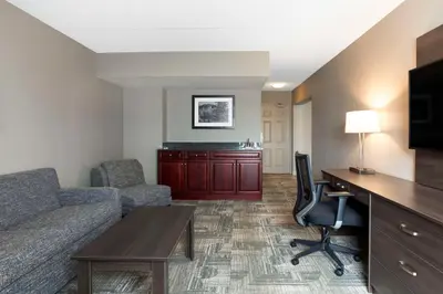 a living room with a couch and a desk with a tv at Best Western Milton in Milton