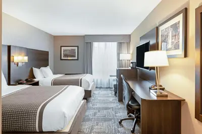 a hotel room with two beds and a desk at Best Western Milton in Milton