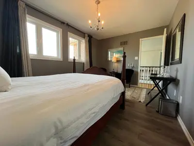 a bedroom with a large white bed and a window at Lulu's Bed & Breakfast in Niagara on the Lake