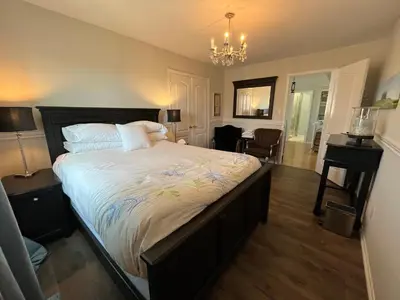 a bedroom with a large bed with a chandelier at Lulu's Bed & Breakfast in Niagara on the Lake