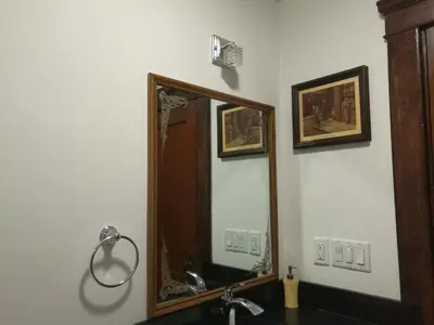 a bathroom with a mirror and a sink at Ambassador's Inn Next Door in Stratford