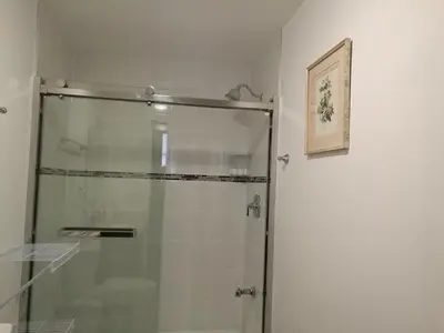 a shower with a glass door in a bathroom at Ambassador's Inn Next Door in Stratford