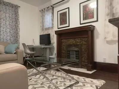 a living room with a fireplace and a glass table at Ambassador's Inn Next Door in Stratford