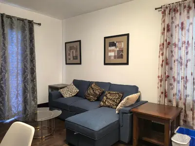 a living room with a blue couch and a table at Ambassador's Inn Next Door in Stratford