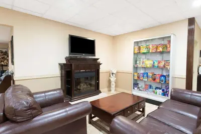 a living room with a fireplace and a tv at Super 8 by Wyndham Cambridge/Kitchener/Waterloo Area in Cambridge