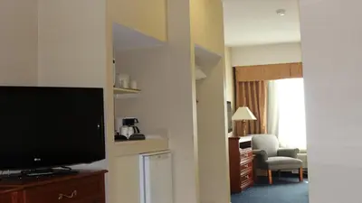 a hotel room with a flat screen tv and a living room at Holiday Inn Express Hotel & Suites Barrie by IHG in Barrie