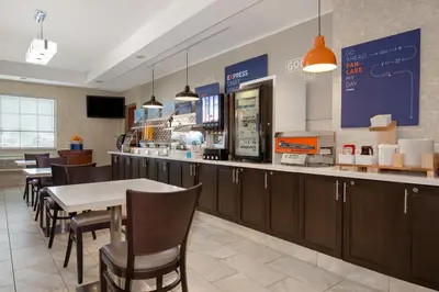 a restaurant with a table and chairs and a counter at Holiday Inn Express Hotel & Suites Barrie by IHG in Barrie
