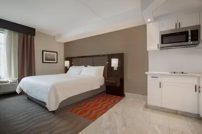 a hotel room with a large bed and a microwave at Holiday Inn Express Hotel & Suites Barrie by IHG in Barrie