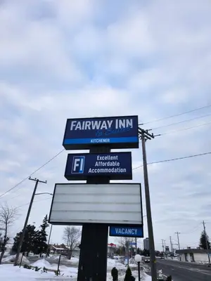 a sign for a farmeway inn on the side of a road at Fairway Inn & Suites in Kitchener