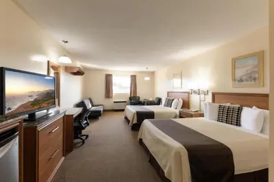 a hotel room with two beds and a flat screen tv at Newmarket Inn in Newmarket