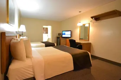 a hotel room with a bed and a desk and a television at Newmarket Inn in Newmarket