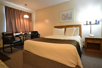 a hotel room with a large bed and a table at Newmarket Inn in Newmarket