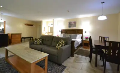 a living room with a couch and a bed at Newmarket Inn in Newmarket