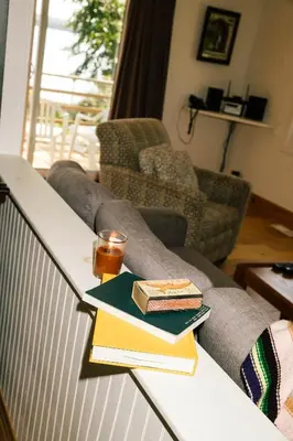 a book and a candle on a table on a balcony at Elmhirst's Resort in Keene