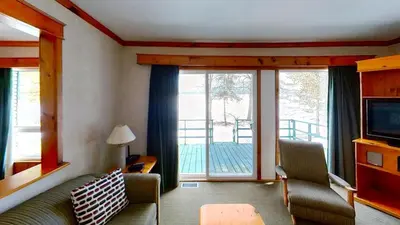 a living room with a couch and a large window at Elmhirst's Resort in Keene