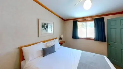 a bedroom with a white bed and a green door at Elmhirst's Resort in Keene
