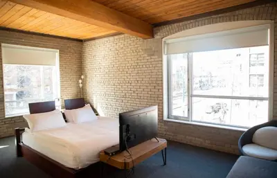 a bedroom with a bed and a large window at Hotel Ocho in Toronto
