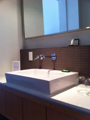 a white sink in a bathroom with a mirror at Hotel Ocho in Toronto